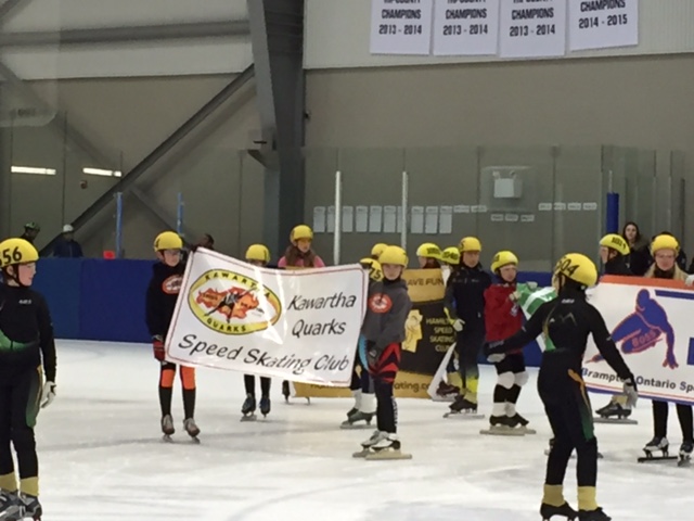 The parade of banners on the ice before the start of a speed skating meet.